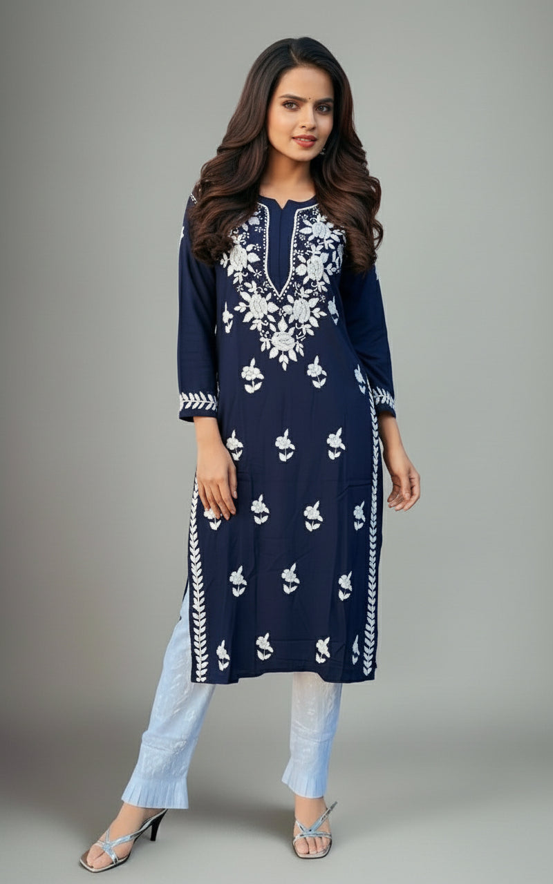 A woman wearing a navy blue Chikankari kurti with Ghass Patti embroidery, paired with white trousers and heels.