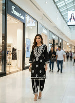 Chikankari kurti with dhoti pants set in black on a mannequin in a store