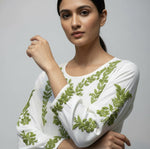 Chikankari kurti with green colour embroidery on white sleeve close up