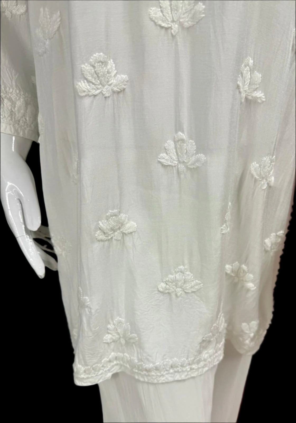 embroidery close up of the lower half of chikankari short kurti with floral motifs