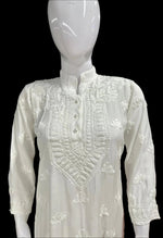 A white Chikankari short kurti displayed on a mannequin, featuring intricate hand embroidery with floral motifs.
