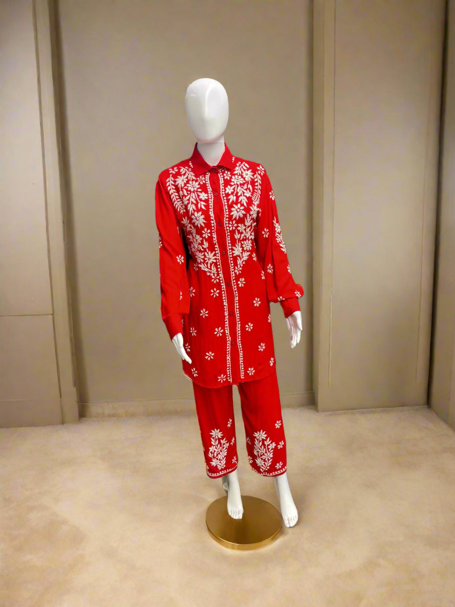 A traditional red and white floral embroidered cord set displayed on a mannequin, consisting of a front-open shirt and matching trousers.