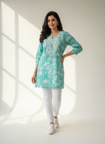 turquoise colour machine embroidered printed short length kurti with white jeans by famaza couture