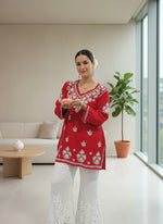 model wearing Chikankari short kurti with V neck in red with white embroidery and white pants
