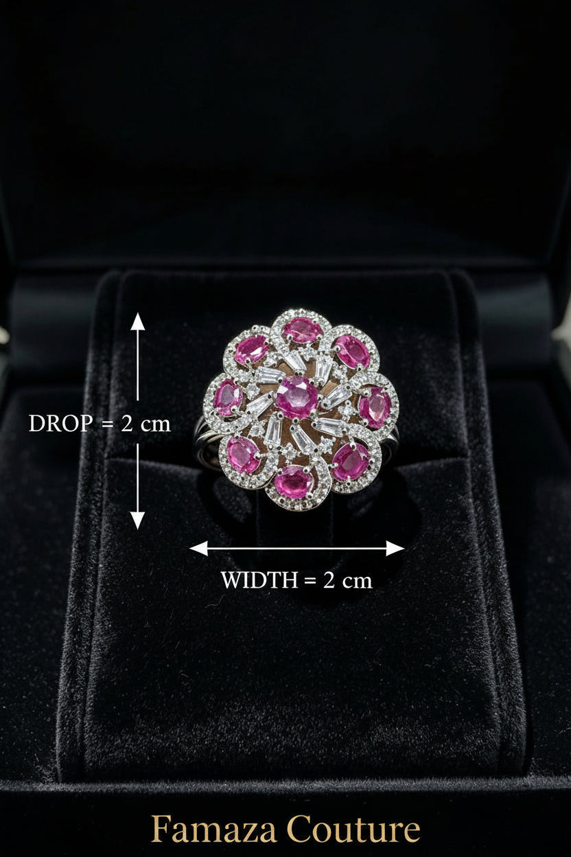 The Famaza Couture Royal Magenta-Pink Floral Cluster Statement Ring displayed inside a luxury black velvet presentation box, highlighting its detailed silver-tone crystal setting and vivid magenta stones.