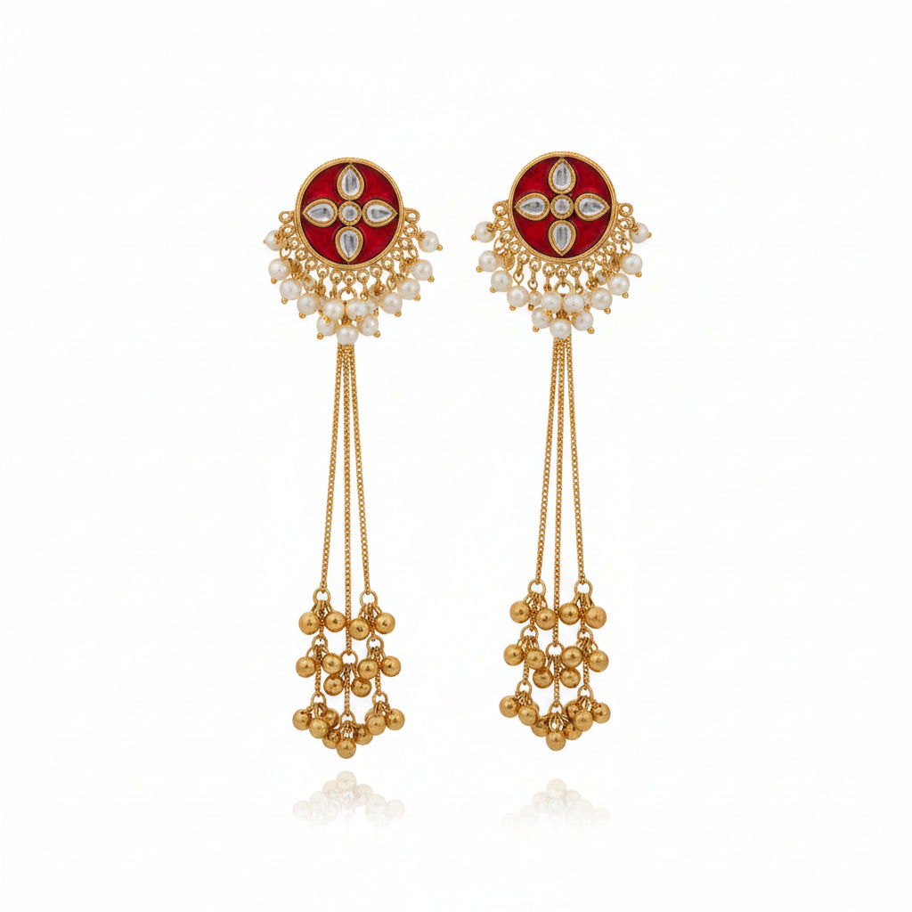filigree jhumka earrings featuring a deep maroon pear-shaped crystal stud and white pearl fringe.
