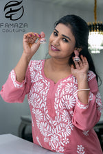 close up view of model wearing Floral chikankari kurti palazzo set in pink with white embroidery