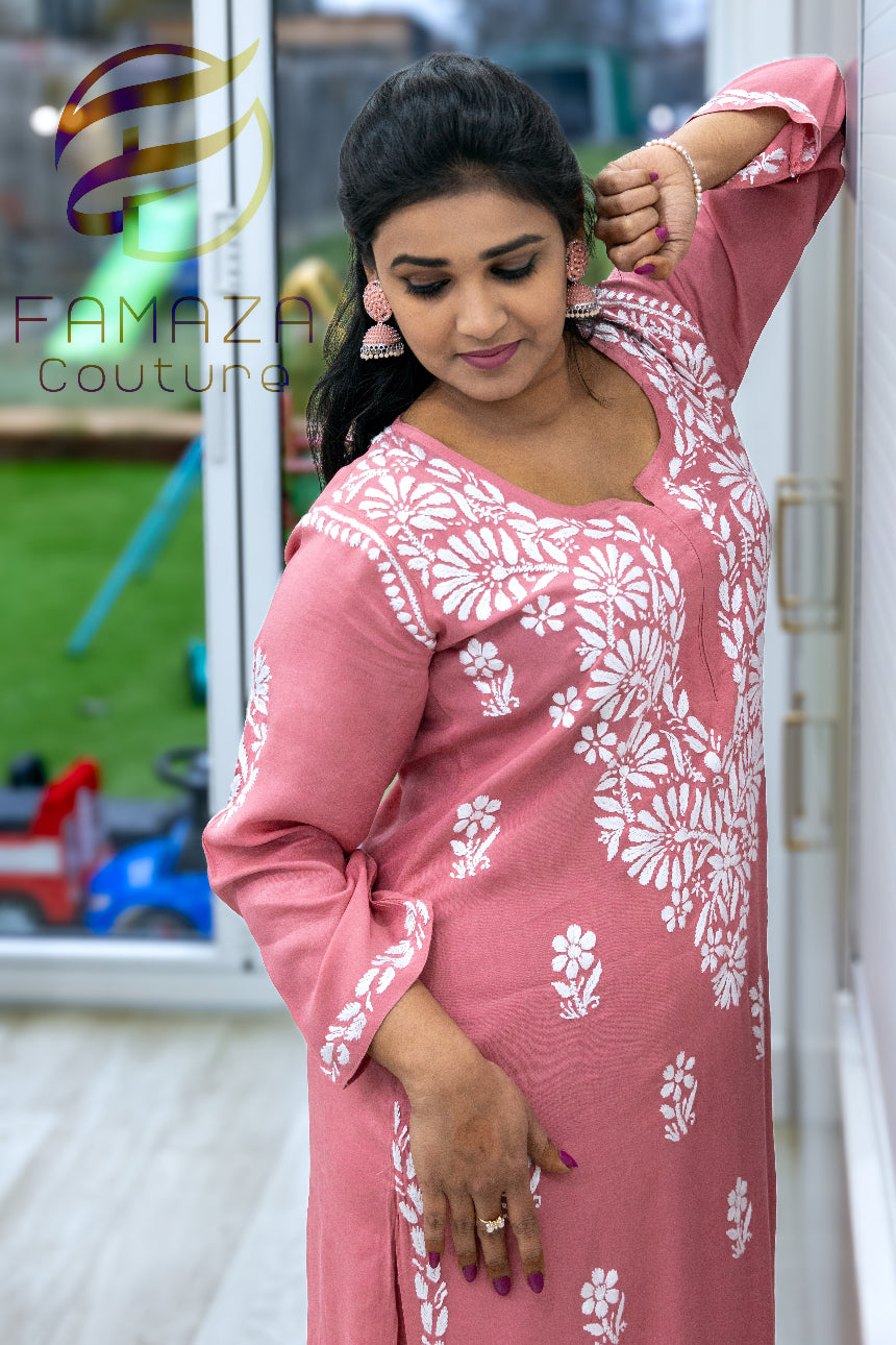 close up side view of model wearing Floral chikankari kurti palazzo set in pink with white embroidery