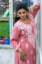 close up side view of model wearing Floral chikankari kurti palazzo set in pink with white embroidery
