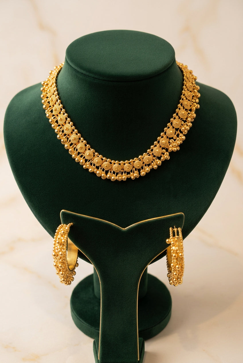 Gilded Grace gold-toned filigree choker and matching bead-trimmed hoop earrings on a green velvet stand