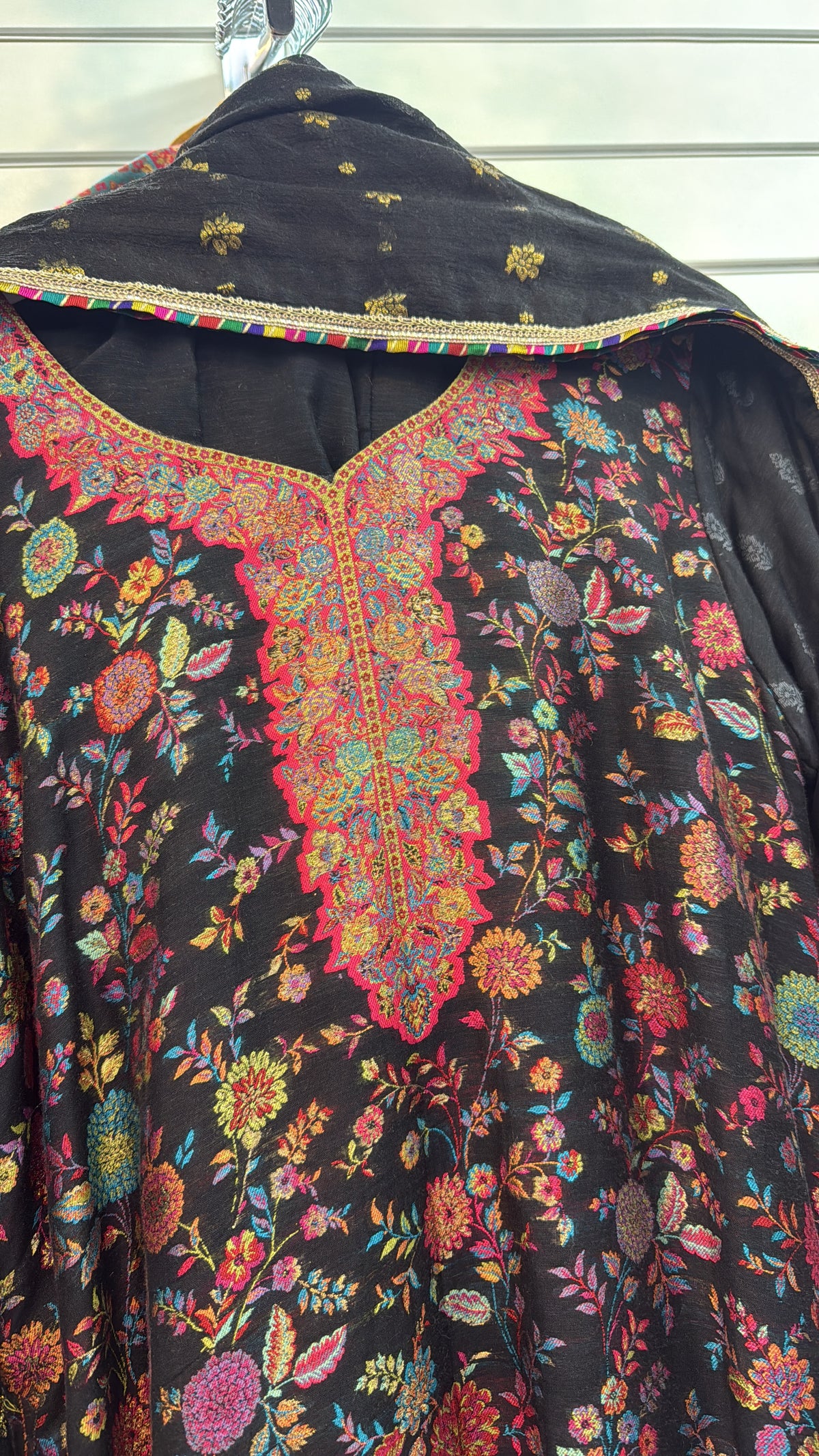 kanni silk kurti and dupatta is displayed on a hanger in a boutique.