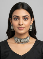 Silver necklace and earrings kundan and pearl set on a black mannequin bust with a blurred backgroundDetails