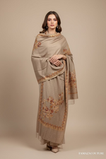 light taupe embroiderer scarf with gold designs on a black stand.