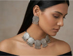 Model wearing the Lotus Whisper oxidised lotus necklace and matching earrings with a black off-shoulder top