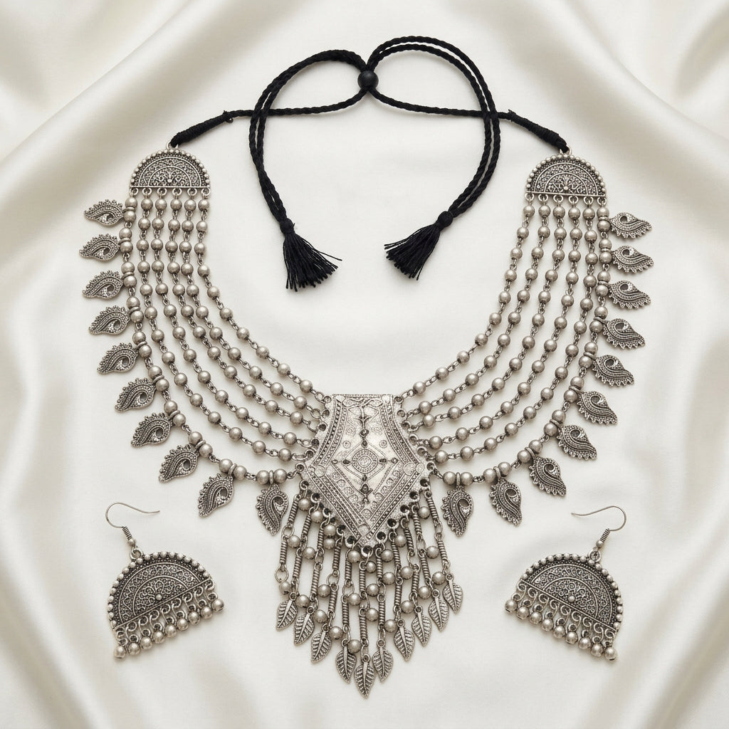 Midnight Heirloom necklace and earrings laid flat, showing paisley charms, pendant fringe and adjustable black cord.