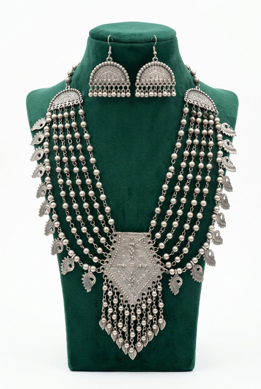 Midnight Heirloom oxidised necklace and fan-shaped earrings on a green bust, with layered beads and paisley charms.