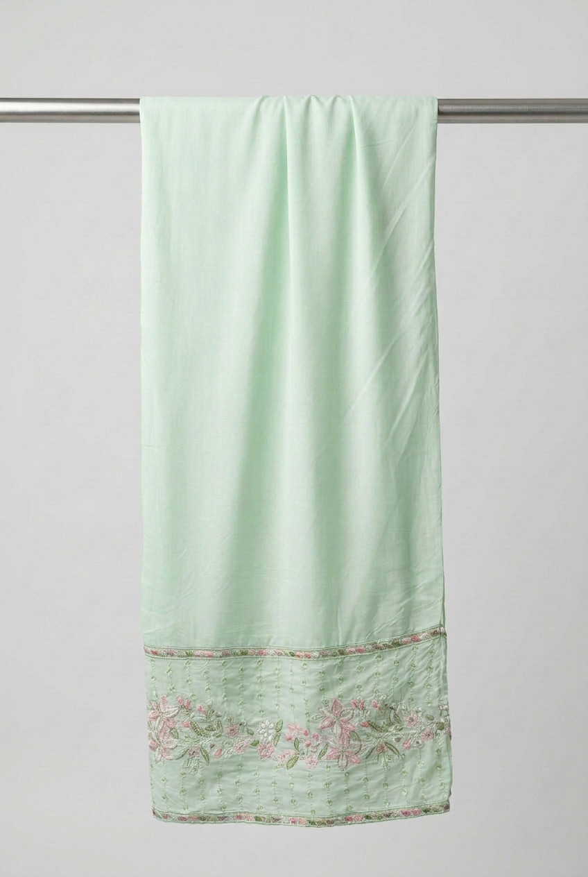 Matching mint green trousers with pink and green floral embroidery around the ankle hem