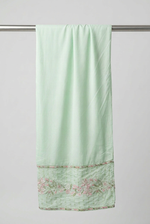 Matching mint green trousers with pink and green floral embroidery around the ankle hem