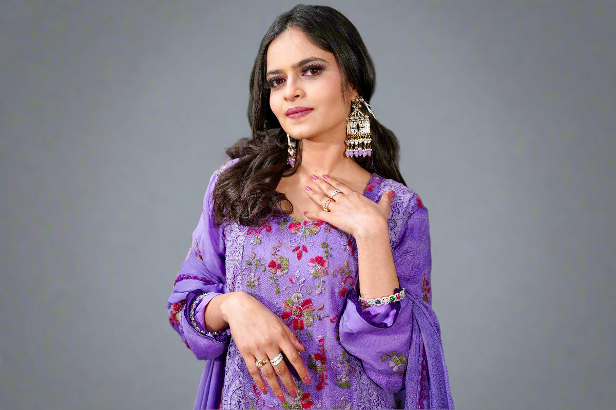 Model wearing Pakistani floral embroidered suit set showing embroidery details