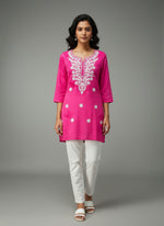 model is wearing this short length hot pink colour kurti in tie & dye colour with white machine embroidery by famaza couture