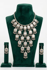 Moonlit Embrace silver-tone cascading disc necklace and matching drop earrings displayed on a green velvet bust.