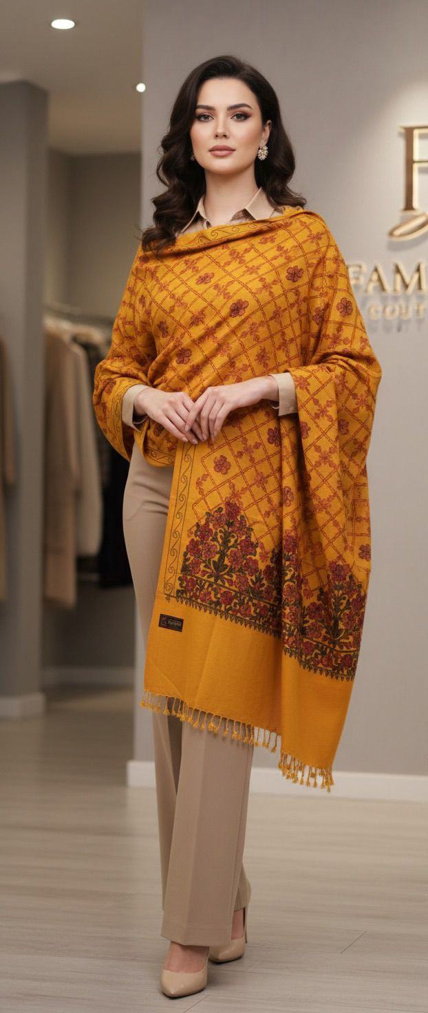 Woman wearing a mustard yellow patterned scarf with a brand logo in the background