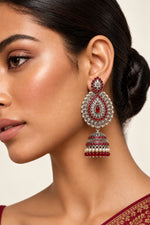 oxidised tone tear drop earrings with red nano stones and hangings are being worn by a posh model side face view.
