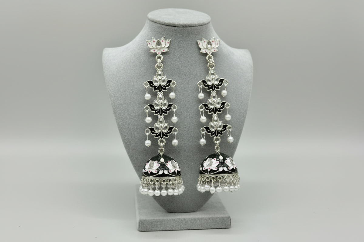 pair of black colour silver-plated tulip-shaped long jhumka earrings with multicolour details, displayed on a black stand.