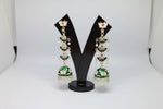 pair of bottle green colour silver-plated tulip-shaped long jhumka earrings with multicolour details, displayed on a black stand.