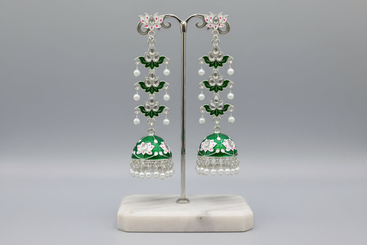 pair of green colour silver-plated tulip-shaped long jhumka earrings with multicolour details, displayed on a black stand.