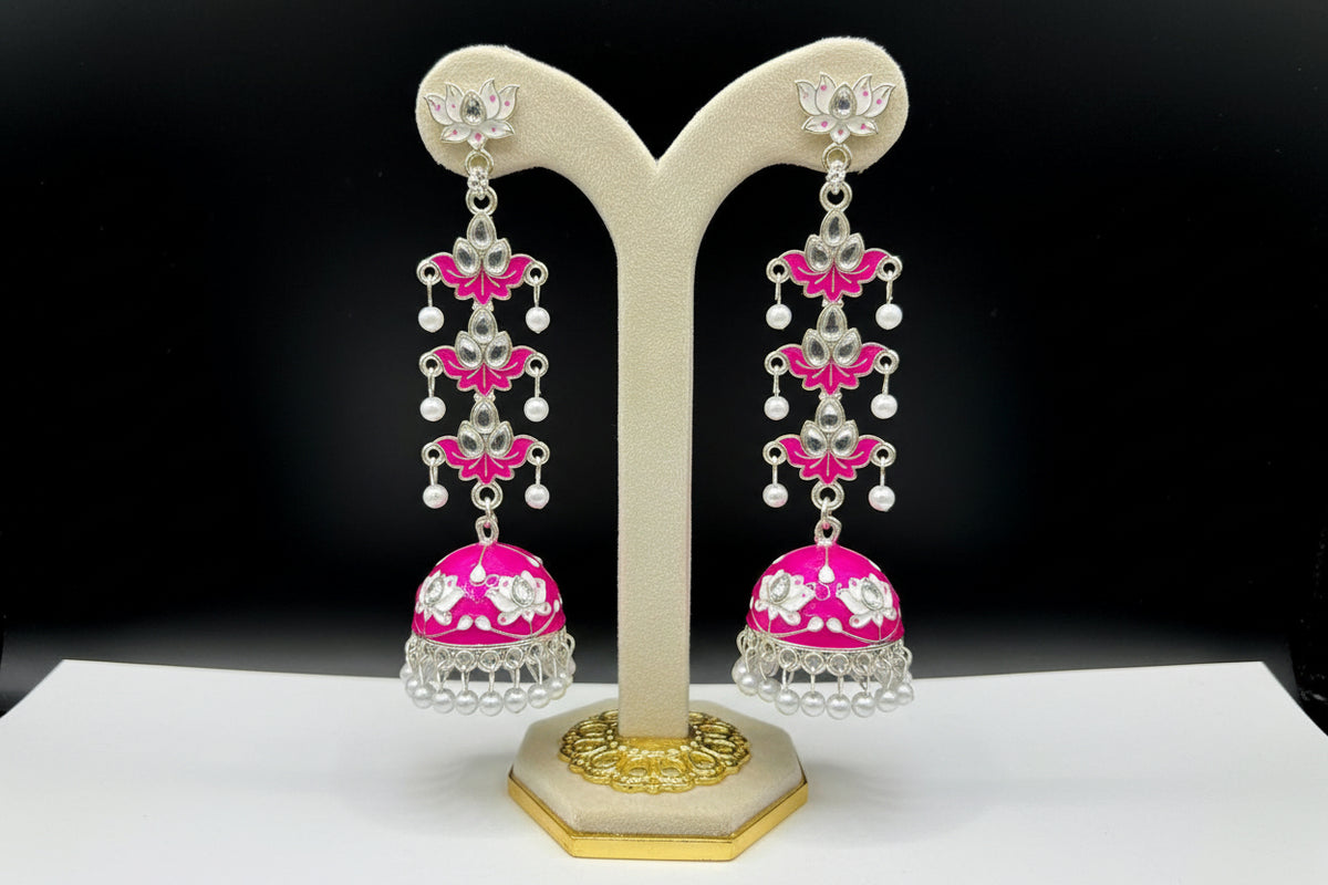 pair of hot pink colour silver-plated tulip-shaped long jhumka earrings with multicolour details, displayed on a black stand.