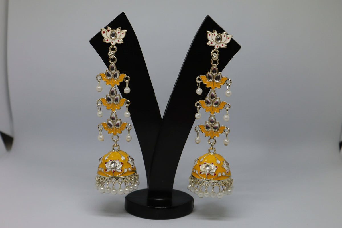 pair of mustard colour silver-plated tulip-shaped long jhumka earrings with multicolour details, displayed on a black stand.