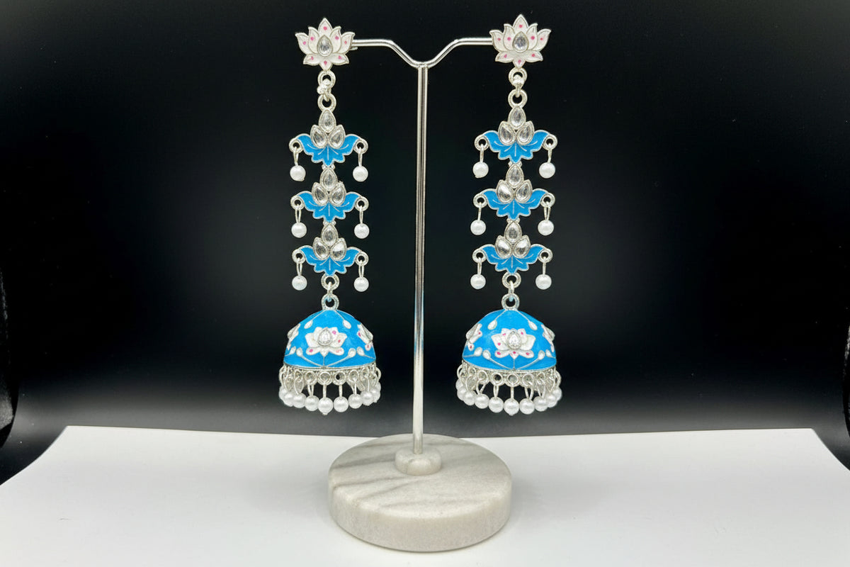 pair of sky blue colour silver-plated tulip-shaped long jhumka earrings with multicolour details, displayed on a black stand.
