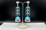 pair of sky blue colour silver-plated tulip-shaped long jhumka earrings with multicolour details, displayed on a black stand.