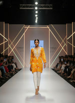 model is wearing this short length orange colour kurti in tie & dye colour with white machine embroidery by famaza couture