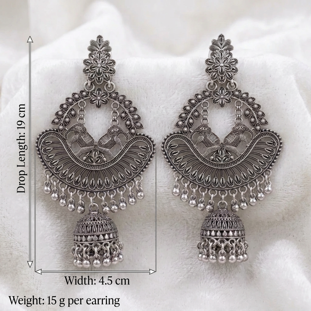 Silver-tone elephant motif chandbali jhumka earrings with floral tops and dangling beads on white fabric
