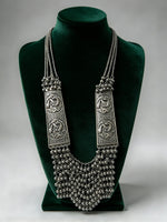 Silver Sonata oxidised long mala necklace with peacock panels and ghungroo fringe on a green bust