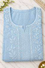 A folded light blue embroidered kurta or tunic with a round neckline and decorative embroidery on the front,