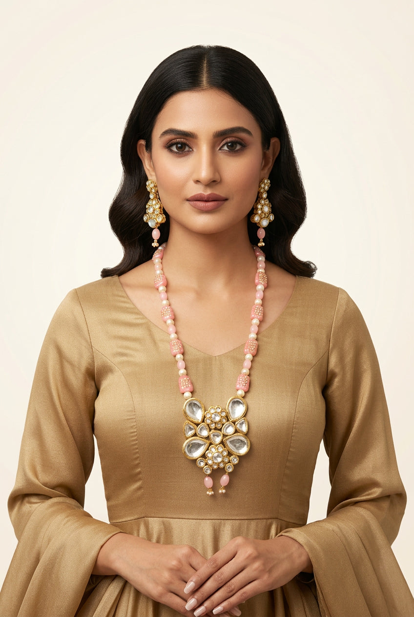 Model wearing a pink beaded Kundan necklace with a gold-tone pendant and matching pink drop earrings.