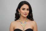 Model wearing a multicoloured beaded Kundan necklace with turquoise-blue accents and matching drop earrings.