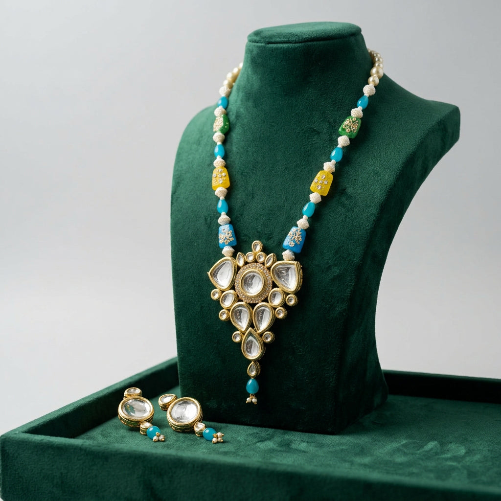 Kundan necklace and matching earrings with turquoise-blue, yellow, green and cream beads on a black display bust.