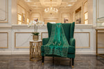Bottle green velvet scarf displayed on a chair, showing decorative borders and scattered motifs.