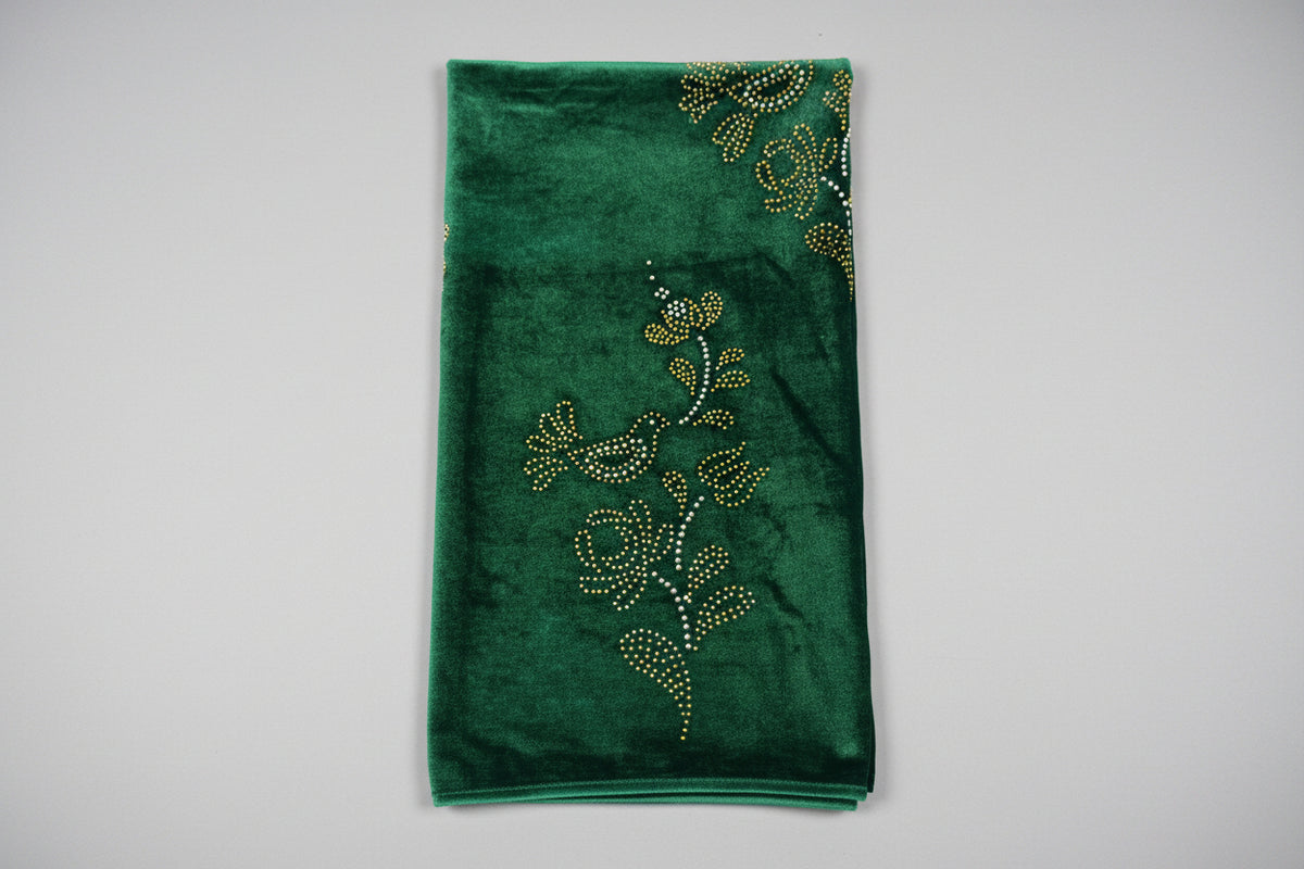 Bottle green velvet scarf draped on a stand with scrolling borders and floral motifs