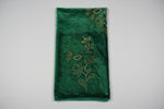 Bottle green velvet scarf draped on a stand with scrolling borders and floral motifs