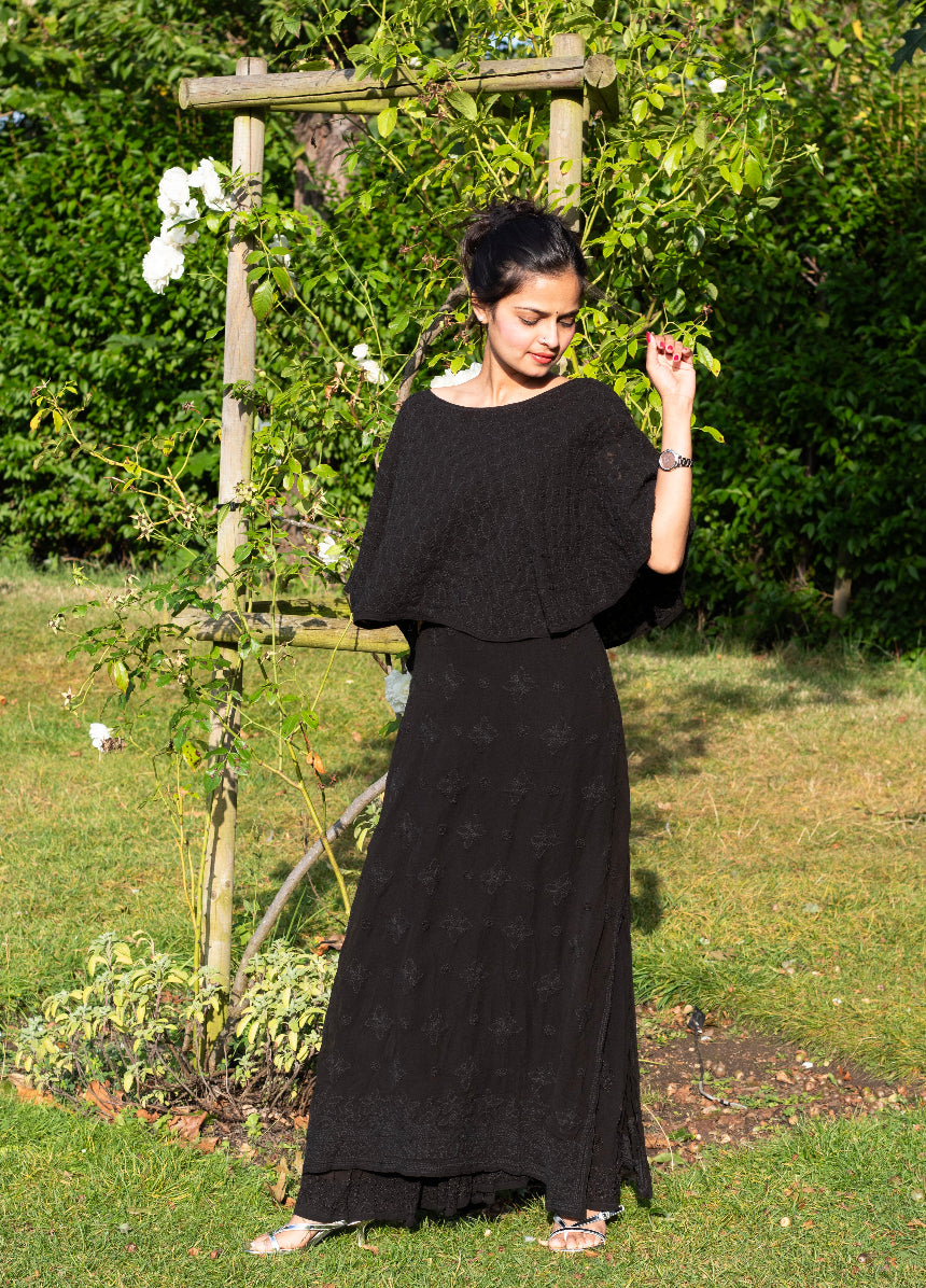 Woman wearing a black dress standing in a garden