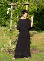 Woman wearing a black dress standing in a garden