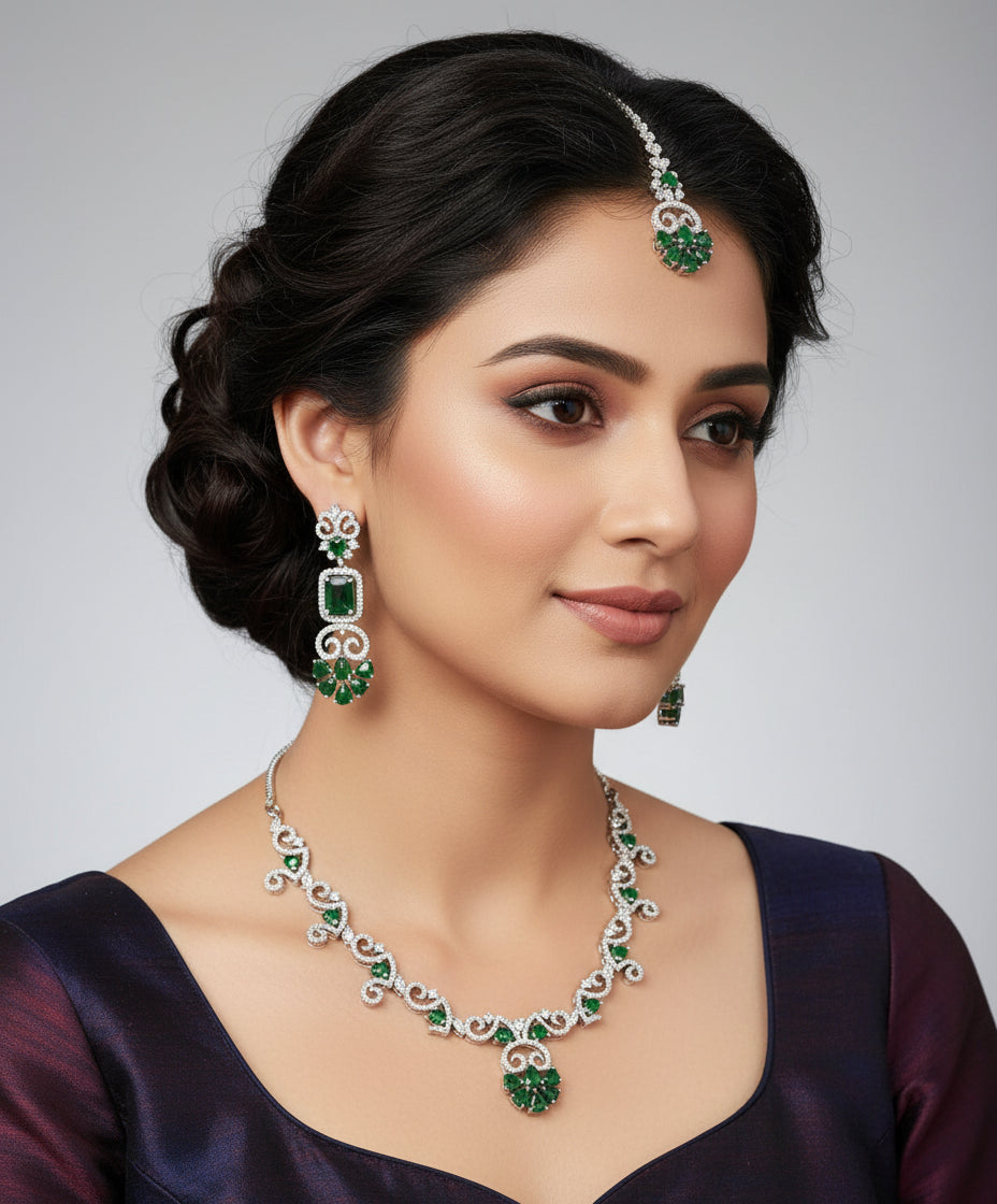 white AD (Artificial Diamond) jewellery set inlcudes a necklace a maang tikka and two earrings with emarlad green centre stones by famaza couture