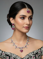 white American diamond stones with hot pink stone in the centre on this jewellery set includes necklace, earrings and maang tikka by famaza couture