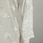 whiteMuslin fabricwith collar Chikankari short length kurti and three buttons on the front, featuring intricate ghasspati hand embroidery with floral motifs by famaza couture