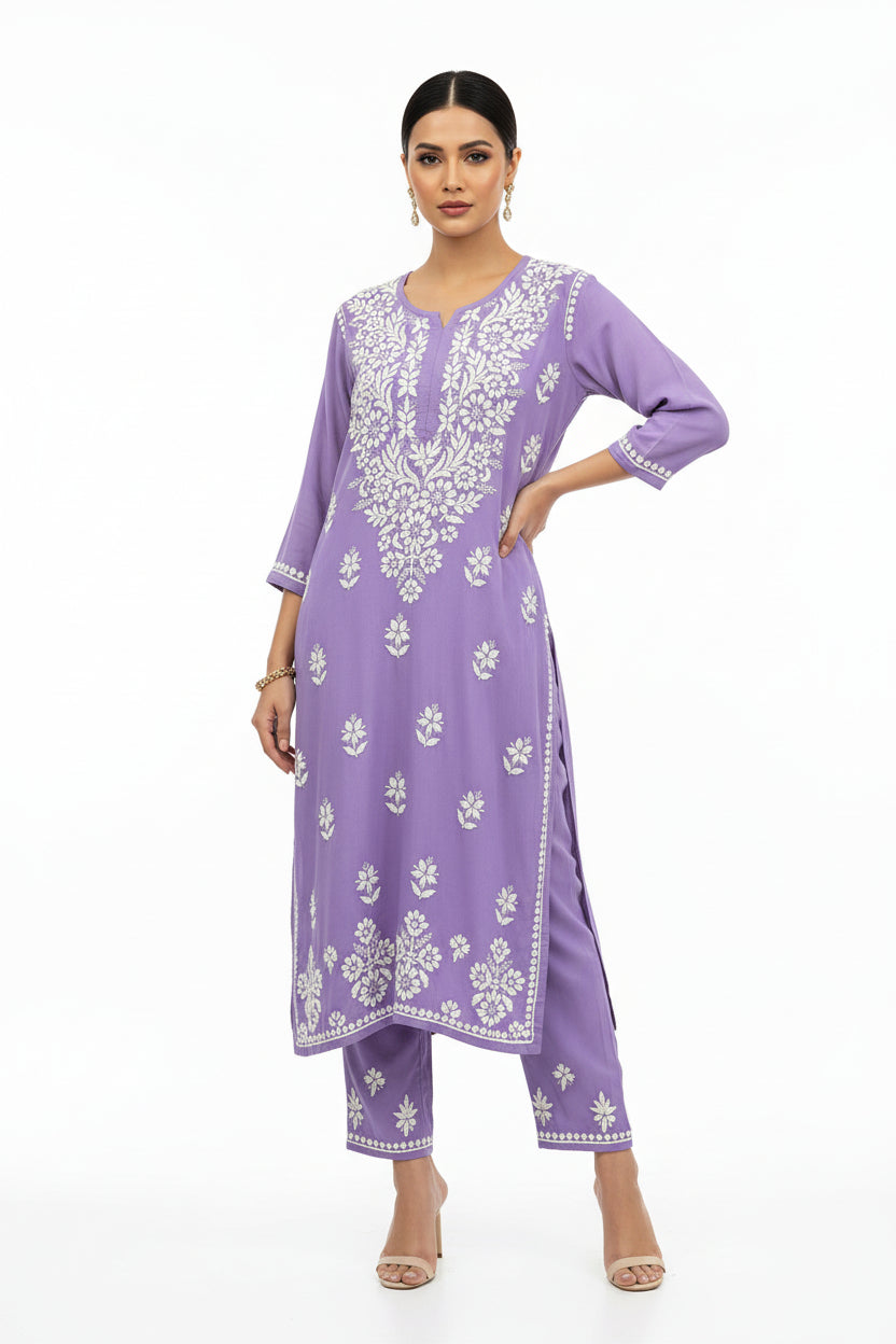 woman is wearing a lilac base rayon fabric 45 inches long kurti and 38 inches long trousers with white hand embroidered outfit with a purewhite background.